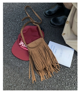 Détail du mini sac en daim marron avec de longues franges et une bandoulière assortie