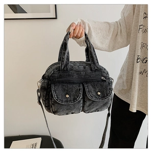 Detail shot of vintage denim crossbody bag with dual front flap pockets and metal buttons