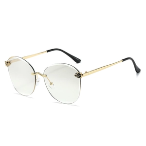 Frameless cat-eye sunglasses with gold metal frame and decorative leopard head detail