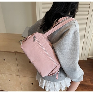 Close-up of a pink canvas tote bag showing the side zipper pocket and wide shoulder strap