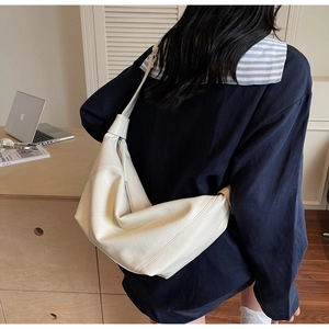 Gros plan du sac hobo blanc cassé à texture litchi dans un cadre de vie décontracté