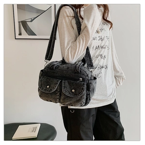 Detail view of retro denim crossbody bag with large front pockets on a model