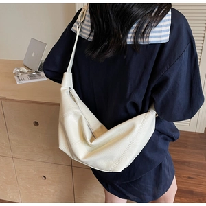 Détail du sac hobo blanc cassé montrant la texture du cuir souple et le profil latéral