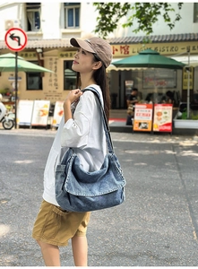 Detail der blauen Denim-Umhängetasche mit verstellbarem Gurt im Street-Style-Look