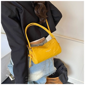 Fashionable bright yellow crinkled leather bag styled with a modern black blazer outfit