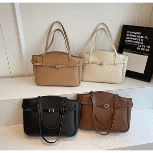 Litchi pattern leather tote bags in four neutral colors displayed on white marble steps