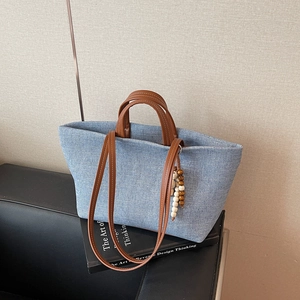 Minimalist large capacity denim canvas tote bag with brown leather straps and beaded charm