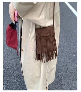 Détail d'un sac bandoulière vintage marron avec de longues franges et aspect daim