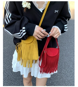 Détail des sacs bandoulière en daim mat avec de longues franges en jaune et rouge
