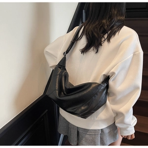 Détail d'un grand sac hobo noir en similicuir souple avec coutures diagonales élégantes