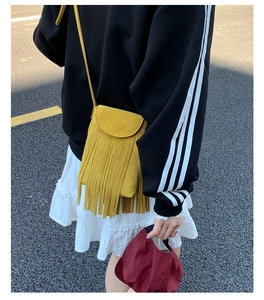 Vue de rue extérieure d'un sac bandoulière jaune à franges avec une tenue de sport