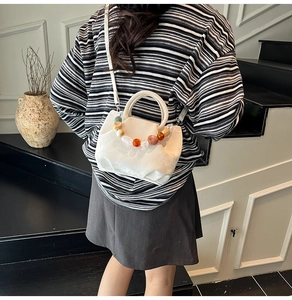 Détail du sac seau blanc avec poignée en perles colorées et sa bandoulière réglable