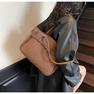 Detail of dark brown lychee grain leather tote bag showing texture and metal buckle