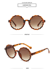 Detailed view of round leopard print sunglasses with wavy edges and tea gradient lenses