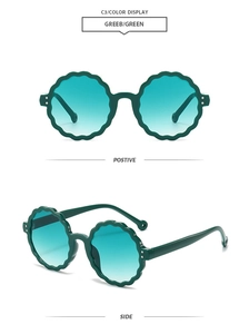 Detail view of round flower petal sunglasses with dark green frames and tinted lenses