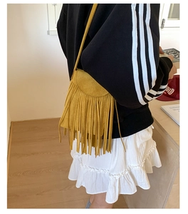 Détail du sac bandoulière en daim jaune avec de longues franges et rabat