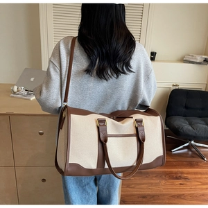 Detail of canvas travel bag with leather accents shown in a professional office setting