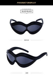 Detail of punk wave-shaped black sunglasses with layered frame and dark lenses