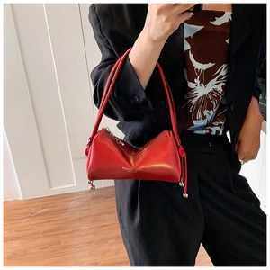 Detail of red leather shoulder bag with silver ball pendant and fashion typography