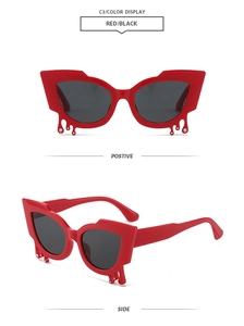 Detail view of red cat-eye sunglasses with unique teardrop crystals and liquid metal accents