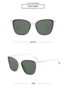 Detail view of retro cat-eye sunglasses with white frame and dark green lenses
