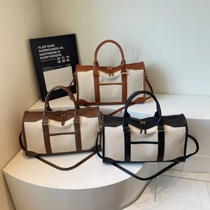 Three canvas travel duffel bags in brown, coffee and black with leather trim and shoulder straps