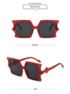 Close-up of red bat-wing shaped sunglasses with wide rectangular black polarized lenses