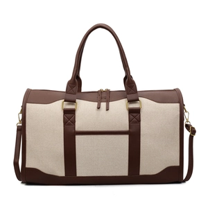 Cream canvas travel duffel bag with brown leather trim and adjustable shoulder strap
