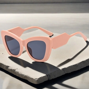 Detail einer korallenrosa Cat-Eye-Sonnenbrille mit breiten Bügeln auf Steinbasis