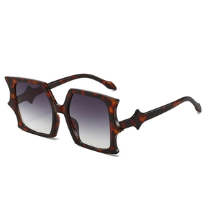 Oversized tortoise shell square sunglasses with bat-shaped irregular frame and grey lenses