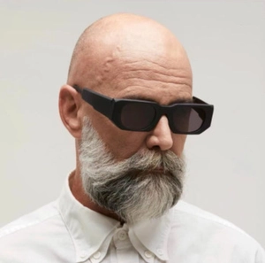 Gros plan de lunettes de soleil carrées noires épaisses portées par un mannequin