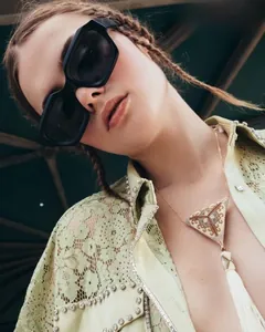 Detailed shot of ethnic beaded triangle necklace with white fringe on a fashion model