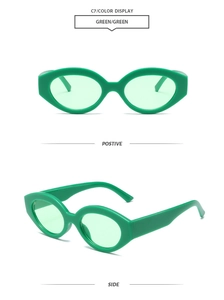 Detail view of vintage green cat-eye sunglasses with thick plastic frames and light green lenses