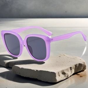 Detail view of purple oversized square sunglasses on stone slab with dark lenses