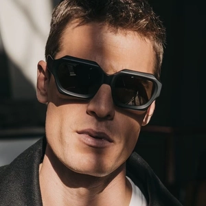 Chic black polygonal wide frame sunglasses with dark UV lenses on a male model