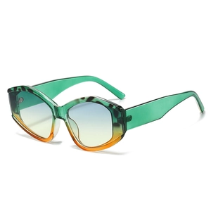 Modern irregular oversized cat-eye sunglasses with green translucent frame and gradient lenses