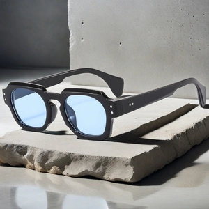 Retro thick black frame sunglasses with irregular edges on a gray stone surface