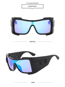 Detail of oversized black sunglasses with blue reflective lenses and geometric broad temples