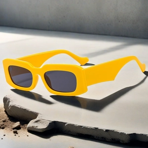 Detail of trendy yellow square frame sunglasses with thick temples on stone background