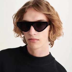Detail of male model wearing retro cat eye sunglasses with sharp black triangle frame