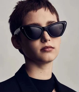 Close-up of retro black cat-eye sunglasses with silver rivet accents on a model