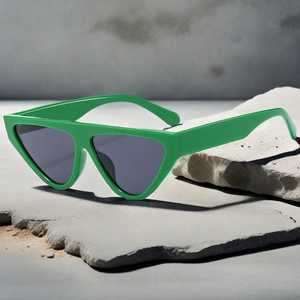 Detailed close-up of bright green cat-eye sunglasses on textured grey stone slab