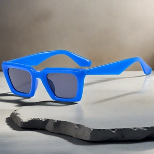 Vue détaillée de lunettes de soleil rectangulaires bleues sur une dalle de pierre grise