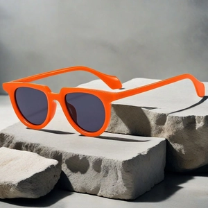 Detail view of oval orange fashion sunglasses on grey stone decorative display