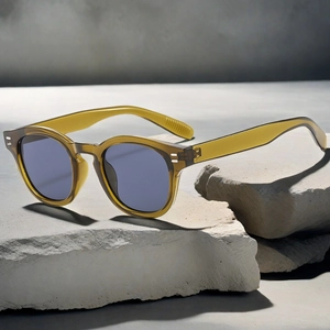 Detailed shot of retro round amber sunglasses placed on natural light gray stone textures