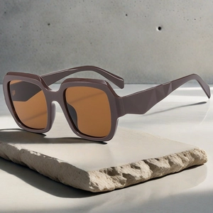 Detail of square oversized sunglasses with brown frame and geometric temples on stone