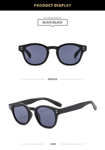 Close-up of black round frame sunglasses featuring silver rivet details and dark lenses