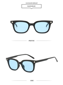 Detail view of square black frames with blue lenses and diamond-shaped metal accents