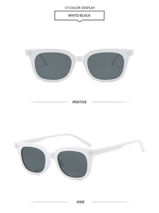 Detail view of square white frame sunglasses with dark lenses and diamond rivets