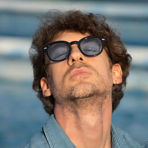 Close-up of retro oval sunglasses with light blue lenses and silver arrow rivets